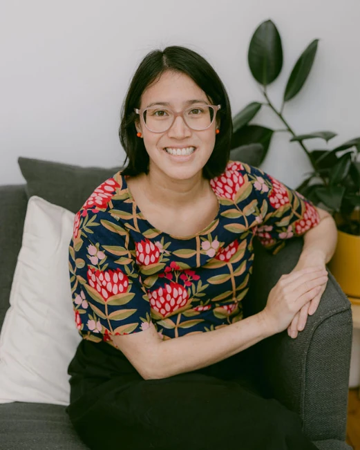 Kim Dang McDonald, grief counsellor, smiling and seated on a sofa